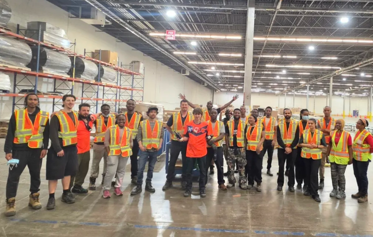 Young Gun crew in warehouse celebrating a team members
