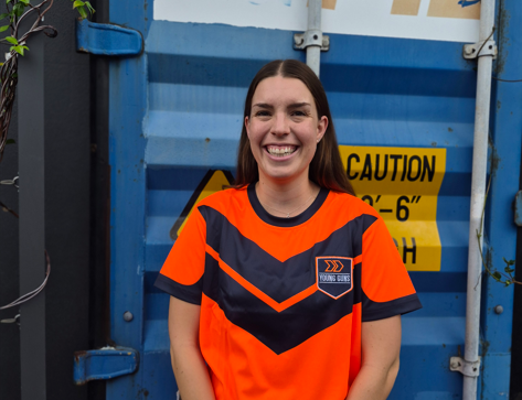 Young Guns team member standing in front of container
